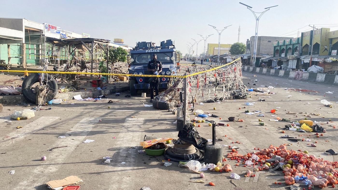 본문 이미지 - 17일(현지시간) 나이지리아 북동부 보르노주 마이두구리의 '먼데이 마켓'에서 발생한 자살 폭탄테러 현장에 경찰 차량이 주차된 모습. 2026.03.17 ⓒ 로이터=뉴스1