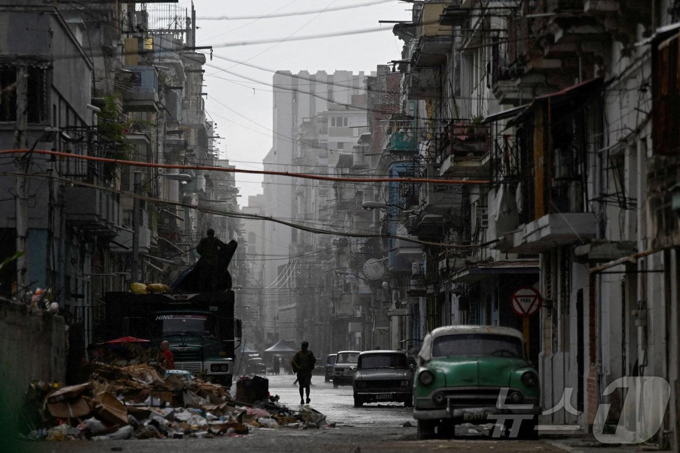 본문 이미지 - 17일(현지시간) 한 남성이 쿠바 아바나 거리를 걷고 있다. 쿠바 에너지광산부에 따르면 전국적인 정전으로 약 1000만 명이 불편을 겪은 뒤, 대부분 지역에서 전력망이 다시 연결됐다. 2026.03.17. ⓒ 로이터=뉴스1