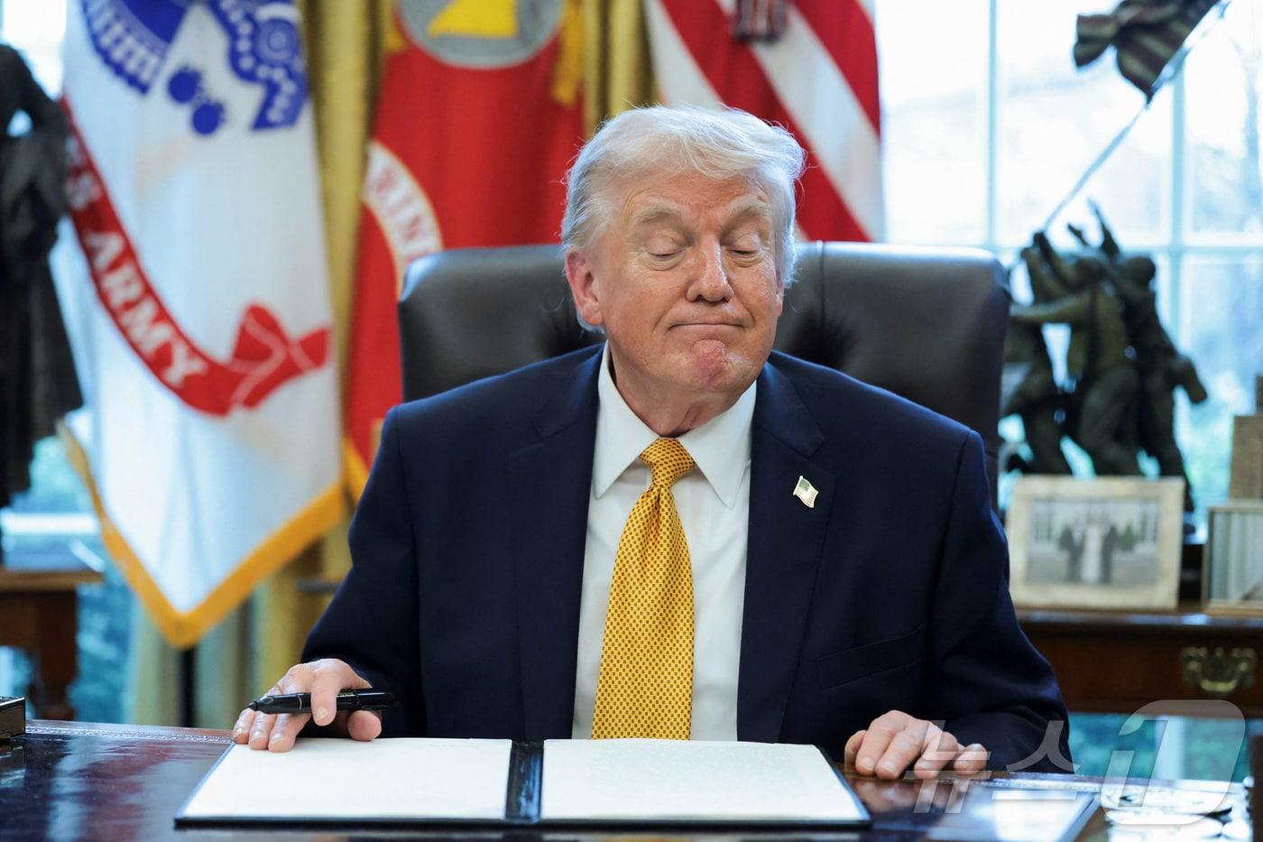 본문 이미지 - 도널드 트럼프 미국 대통령이 16일(헌지시간) 워싱턴DC 백악관 집무실에서 JD 밴스 부통령이 이끄는 사기 방지 태스크포스 창성 행정명령에 서명하고 있다. 2026.3.16 ⓒ 로이터=뉴스1