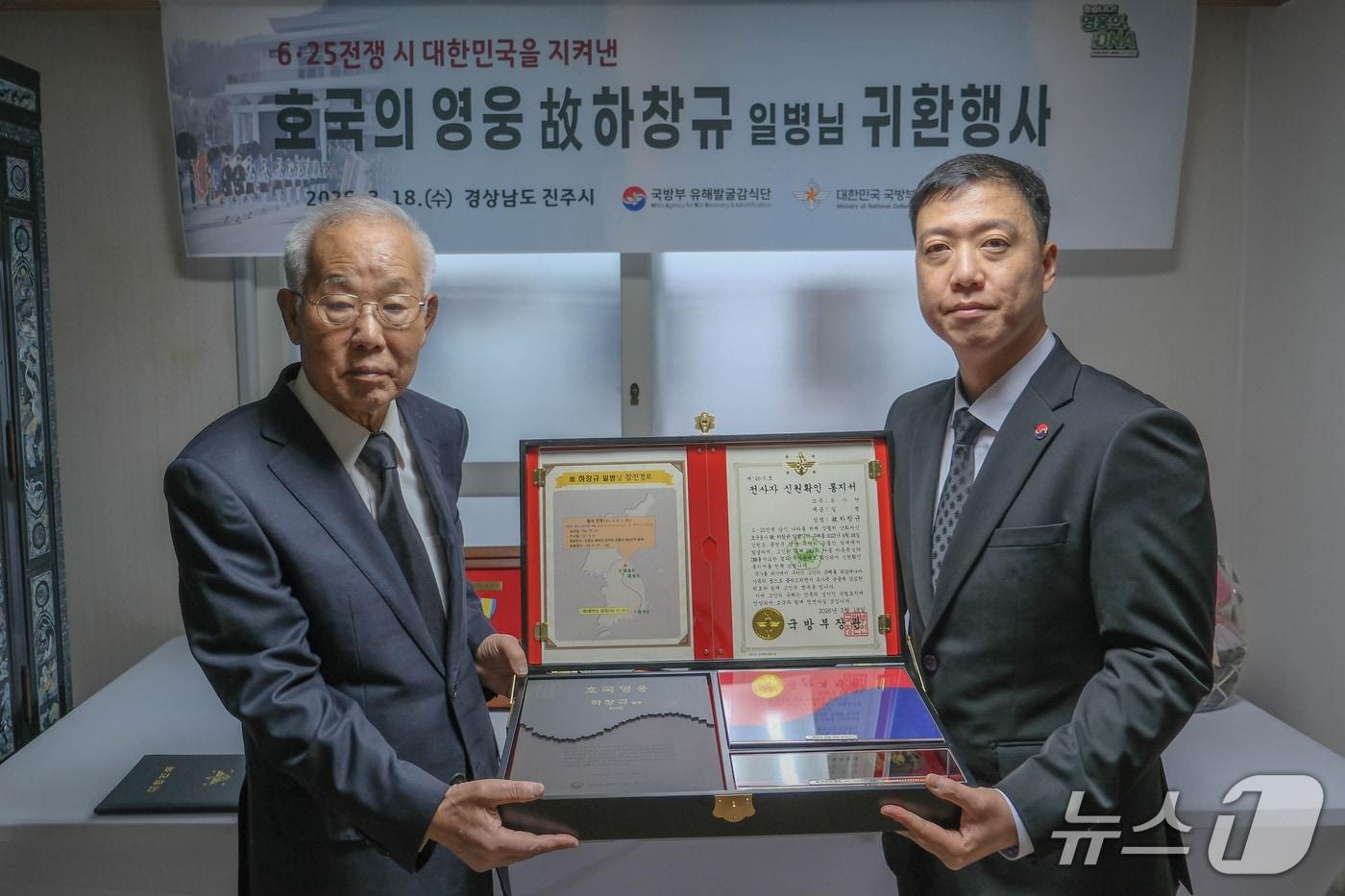 본문 이미지 - 김성환 국방부 유해발굴감식단장 직무대리(육군 중령)는 18일 경남 진주시 고(故) 하창규 일병의 아들 종복 씨(74세) 자택에서 열린 호국영웅 귀환행사에서 전사자 신원 확인 통지서 등이 담긴 '호국의 얼' 함을 전달했다. 2026.3.18./ⓒ 뉴스1(국방부 유해발굴감식단 제공)