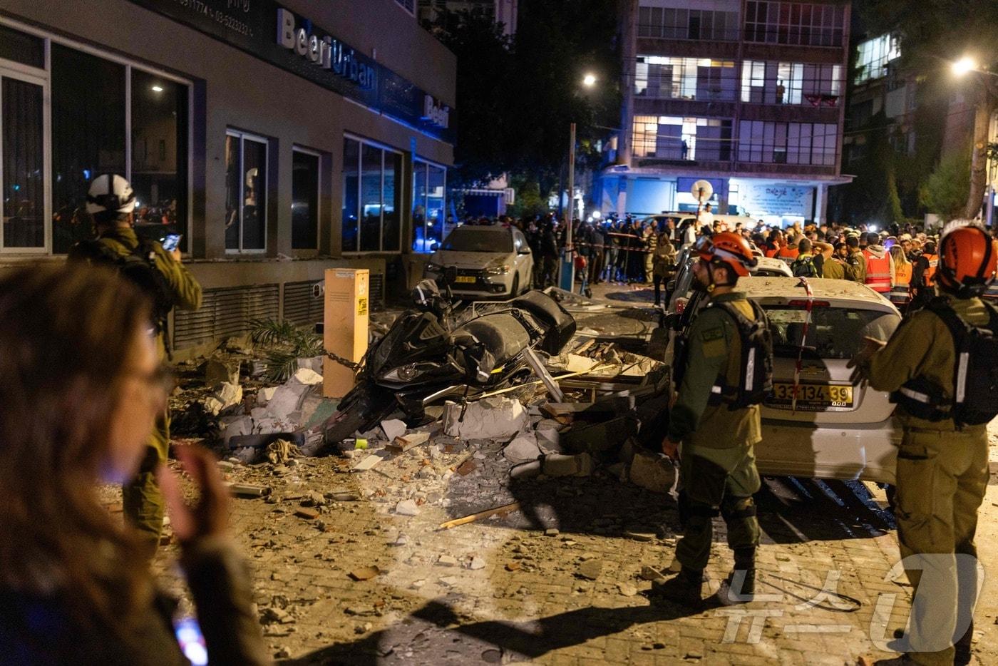 본문 이미지 - 18일(현지시간) 이스라엘 텔아비브 인근도시 라마트간에서 군인들이 미사일 공격으로 피해를 입은 아파트를 조사하고 있다. 2026.03.18. ⓒ AFP=뉴스1