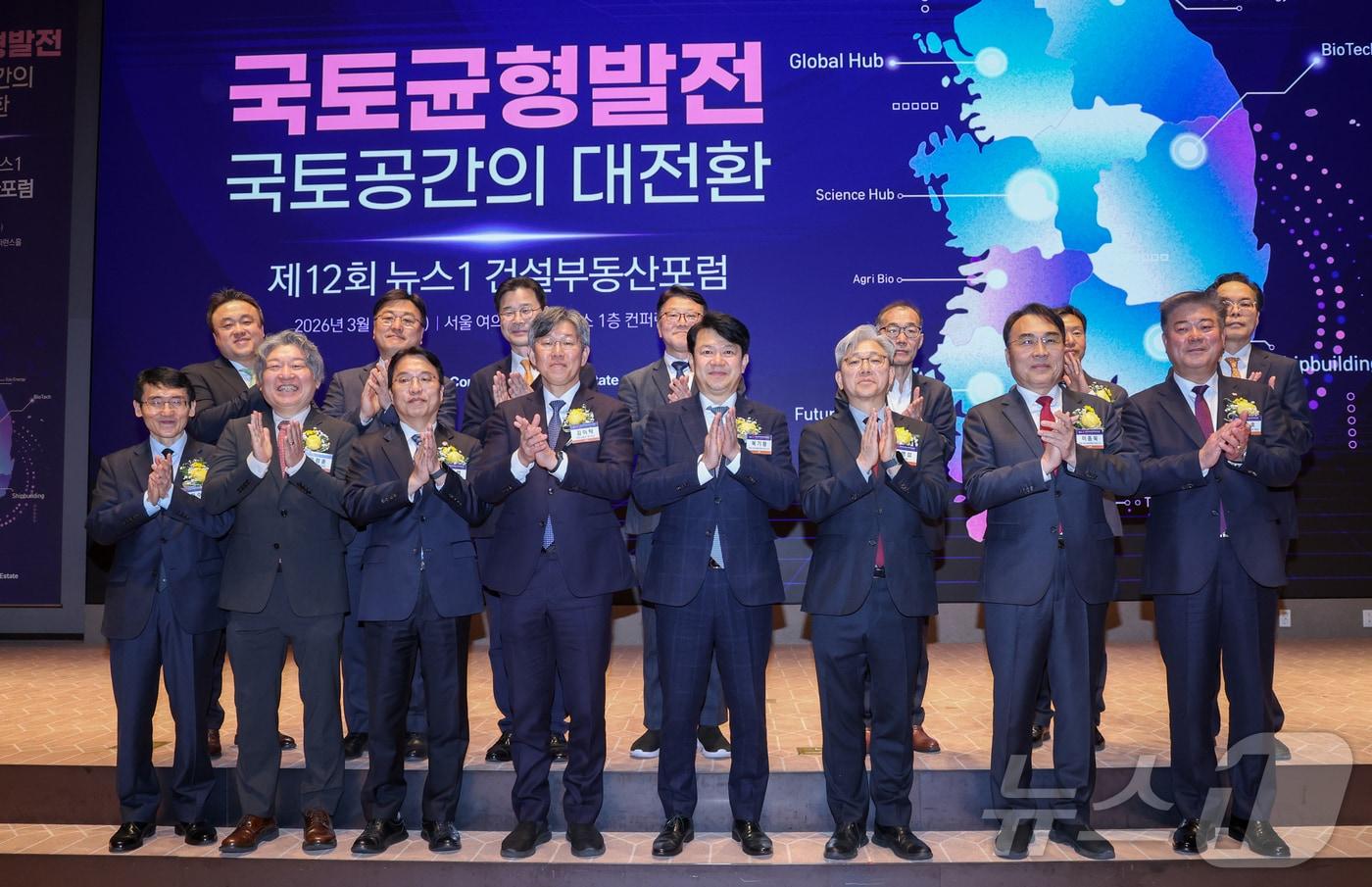 본문 이미지 - 18일 오후 서울 여의도 한국거래소에서 열린 제12회 뉴스1 건설부동산포럼에서 이영섭 대표이사를 비롯한 내빈들이 기념 촬영을 하고 있다. 앞줄 왼쪽부터 김희수 대한건설정책연구원장, 유정훈 대한교통학회장, 강주엽 행정중심복합도시건설청장, 김이탁 국토교통부 제1차관, 국회 국토교통위원회 여당 간사인 복기왕 더불어민주당 의원, 이 대표, 국토위 야당 간사인 이종욱 국민의힘 의원, 김종호 한국공인중개사협회장. 2026.3.18 ⓒ 뉴스1 안은나 기자