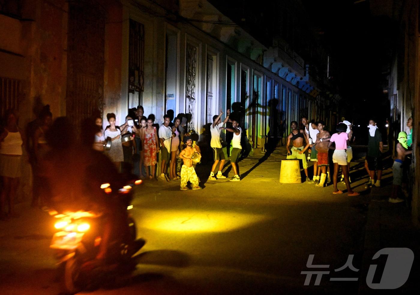 본문 이미지 - 쿠바 아바나에 대규모 정전 사태가 발생한 가운데 쿠바 시민들이 거리에 모여 있는 모습. 2026.03.16. ⓒ 로이터=뉴스1