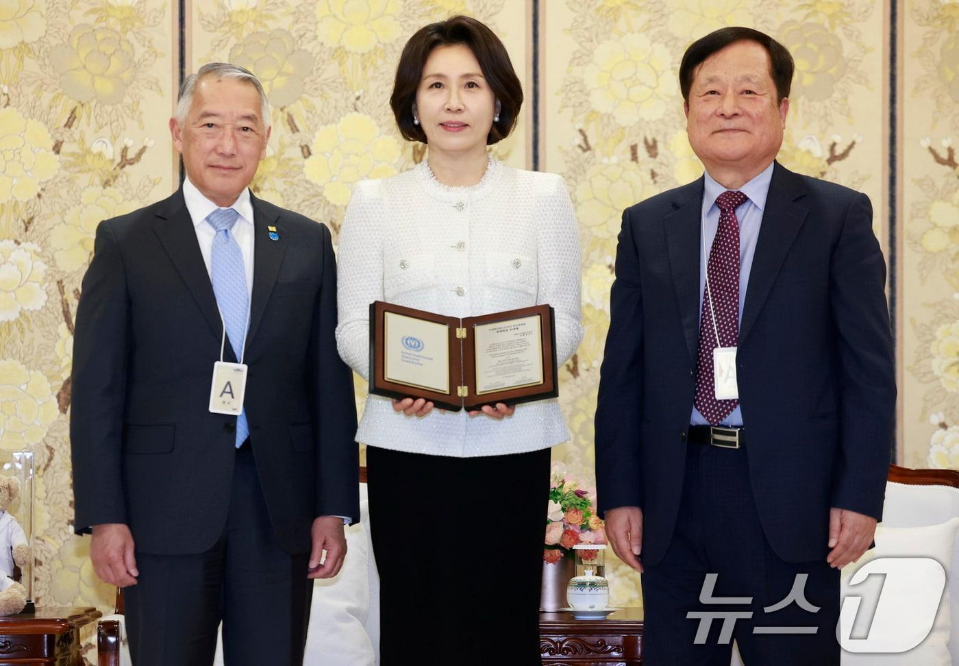 본문 이미지 - 김혜경 여사가 18일 청와대에서 박상철 국제백신연구소(IVI) 한국후원회 회장에게 추대패를 전달 받은 후 기념촬영을 하고 있다. 왼쪽은 제롬 김 IVI 사무총장. (청와대통신사진기자단) 2026.3.18 ⓒ 뉴스1 이재명 기자