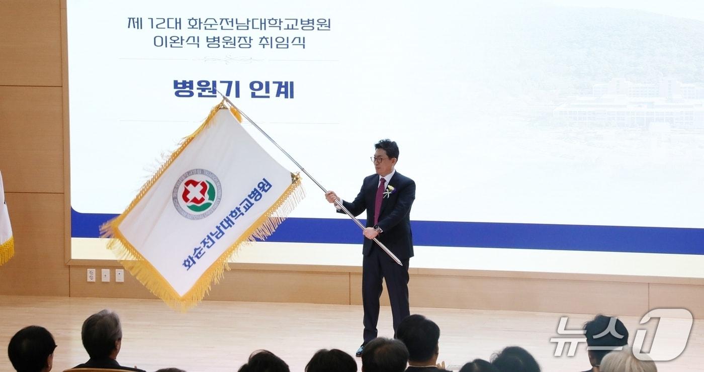 본문 이미지 - 화순전남대학교병원 제12대 이완식 병원장이 취임식에서 병원기를 들고 있다. (사진=화순전남대병원 제공.) 2026.3.18