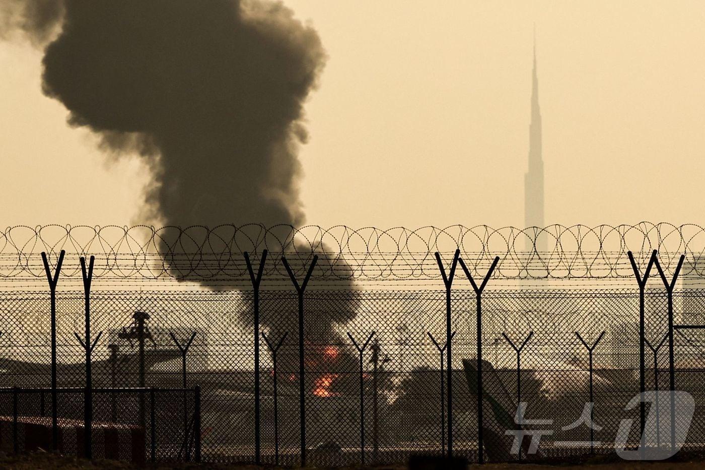 본문 이미지 - 16일(현지시간) 두바이 국제공항 인근에서 드론 사고로 인한 화재로 연기 기둥이 피어오르고 있다. 2026.3.16 ⓒ AFP=뉴스1 (자료사진)
