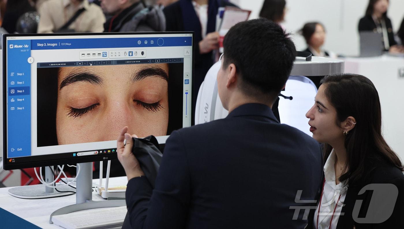 본문 이미지 - 사진은 서울 강남구 코엑스에서 열린 제41회 국제의료기기·병원설비 전시회(KIMES 2026)를 찾은 외국인 관람객이 3D 안면 피부진단기 체험을 하고 있는 모습. 2026.3.19 ⓒ 뉴스1 김진환 기자