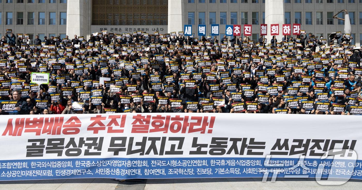 본문 이미지 - 19일 서울 여의도 국회 본청 앞 계단에서 열린 대형마트 온라인 새벽배송 추진 반대 집회에서 참가자들이 대형마트 새벽배송 추진 철회를 촉구하고 있다. 2026.3.19 ⓒ 뉴스1 이승배 기자