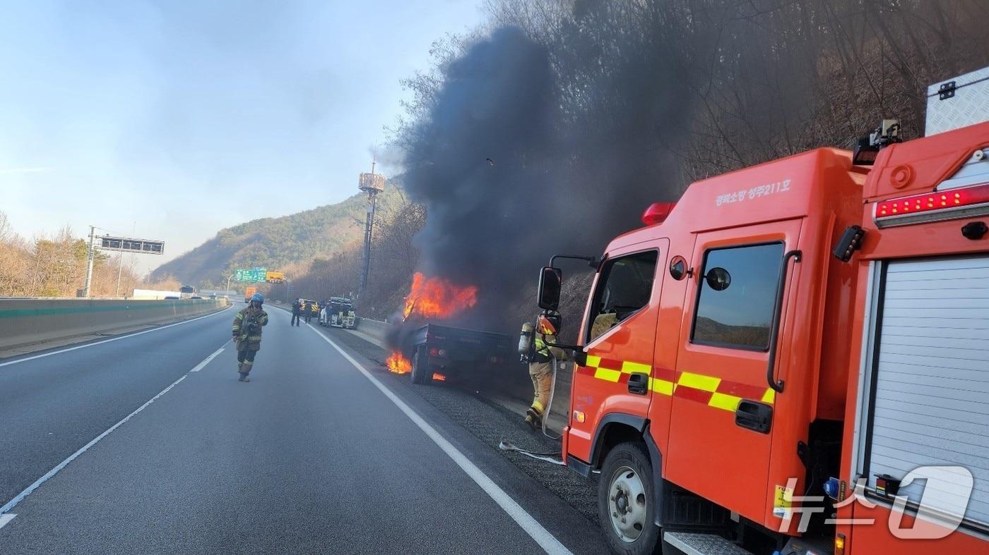 본문 이미지 - 19일 오전 8시29분쯤 경북 성주군 초전면 용봉리 중부내륙고속도로 양평 방향 100㎞ 지점을 달리던 1톤 화물차에 불이나 소방대원들이 진화하고 있다.(경북소방본부 제공. 재판매 및 DB 금지)2026.3.19/뉴스1
