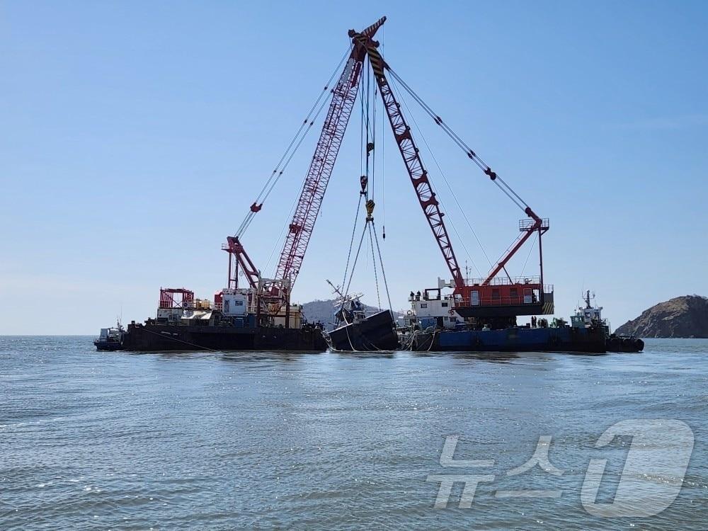 본문 이미지 - 지난 6일 오후 3시 55분경 충남 보령시 오천면 소화사도 동쪽 약 1.4km 해상에서 발생한 침몰어선 A호(69톤, 근해안강망)가 19일 해상크레인선 2척에 의해 인양되고 있다. 인양된 A호는 대천항으로 입항할 예정이며, 보령해경은 실종된 A호 선장을 찾고 있다.(보령해경 제공. 재판매 및 DB금지) 2026.3.19 ⓒ 뉴스1 김기태 기자