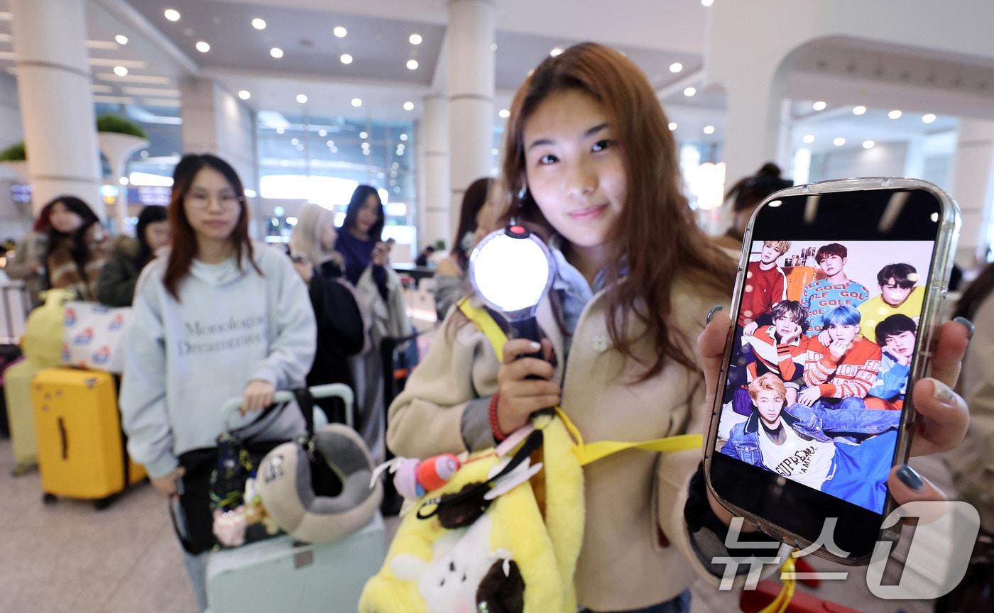 본문 이미지 - 19일 인천국제공항에서 BTS 팬클럽 ‘아미’인 중국인 클로이(20)가 입국하며 아미밤(방탄소년단 공식 응원봉)을 들어 보이고 있다. 오는 21일 서울 광화문광장에서 열리는 BTS 컴백 공연을 관람하기 위해 전 세계 ‘아미’(BTS 팬)들이 속속 한국을 찾고 있다. 2026.3.19 ⓒ 뉴스1 박지혜 기자
