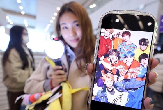 본문 이미지 - 19일 인천국제공항에서 BTS 팬클럽 ‘아미’인 중국인 클로이(20)가 입국하며 아미밤(방탄소년단 공식 응원봉)을 들어 보이고 있다. 오는 21일 서울 광화문광장에서 열리는 BTS 컴백 공연을 관람하기 위해 전 세계 ‘아미’(BTS 팬)들이 속속 한국을 찾고 있다. 2026.3.19 ⓒ 뉴스1 박지혜 기자