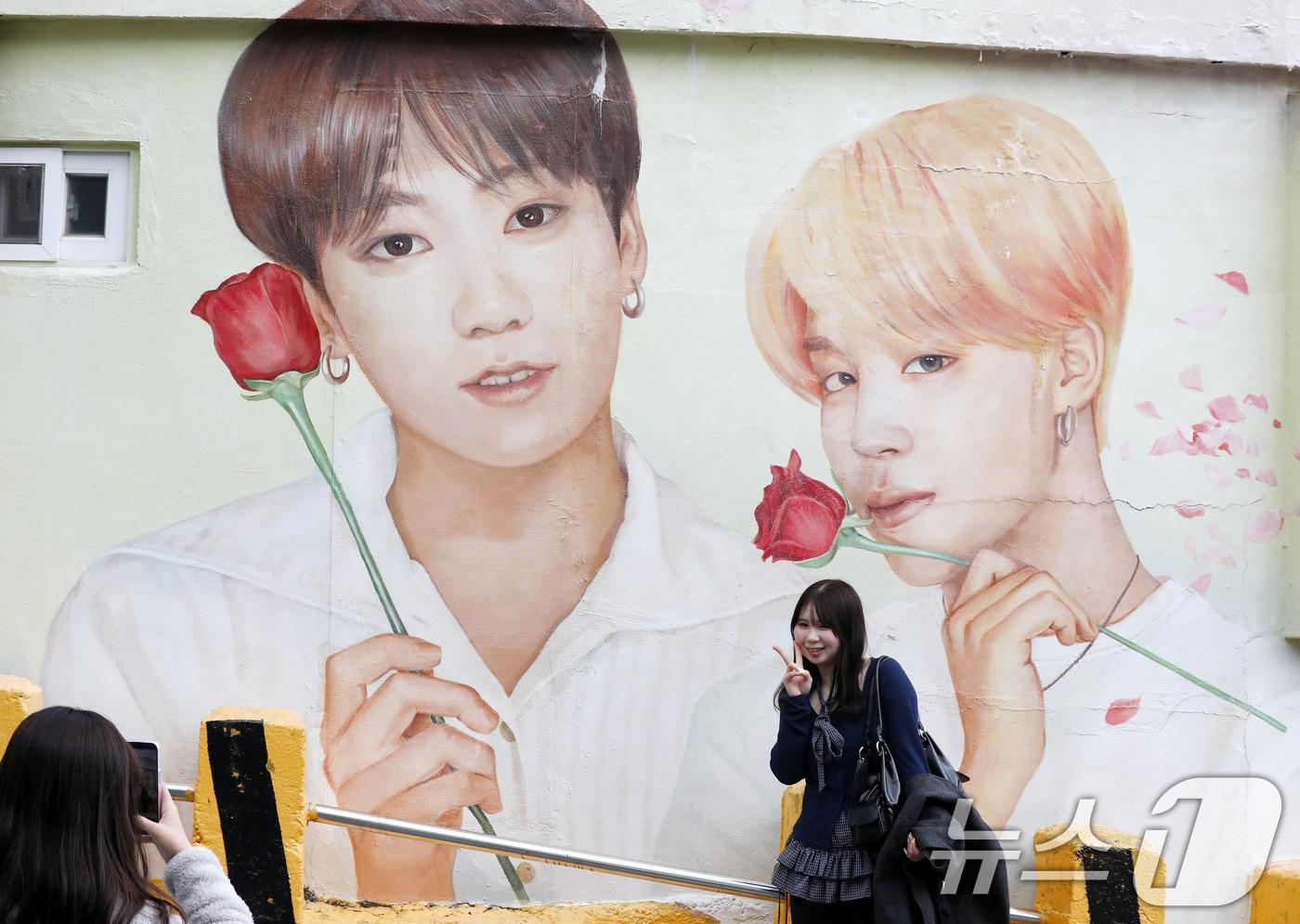 본문 이미지 - 부산 서구 감천문화마을에서 외국인 관광객들이 부산이 고향인 BTS 멤버 정국·지민이 그려진 대형 벽화를 배경으로 기념촬영을 하고 있다. 2026.3.19 ⓒ 뉴스1 윤일지 기자