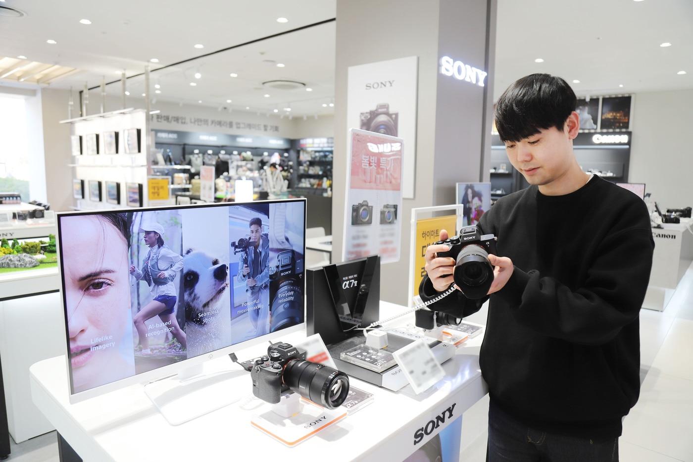 본문 이미지 -  모델이 롯데하이마트에서 카메라 제품을 살펴보고 있는 모습.(롯데하이마트 제공)