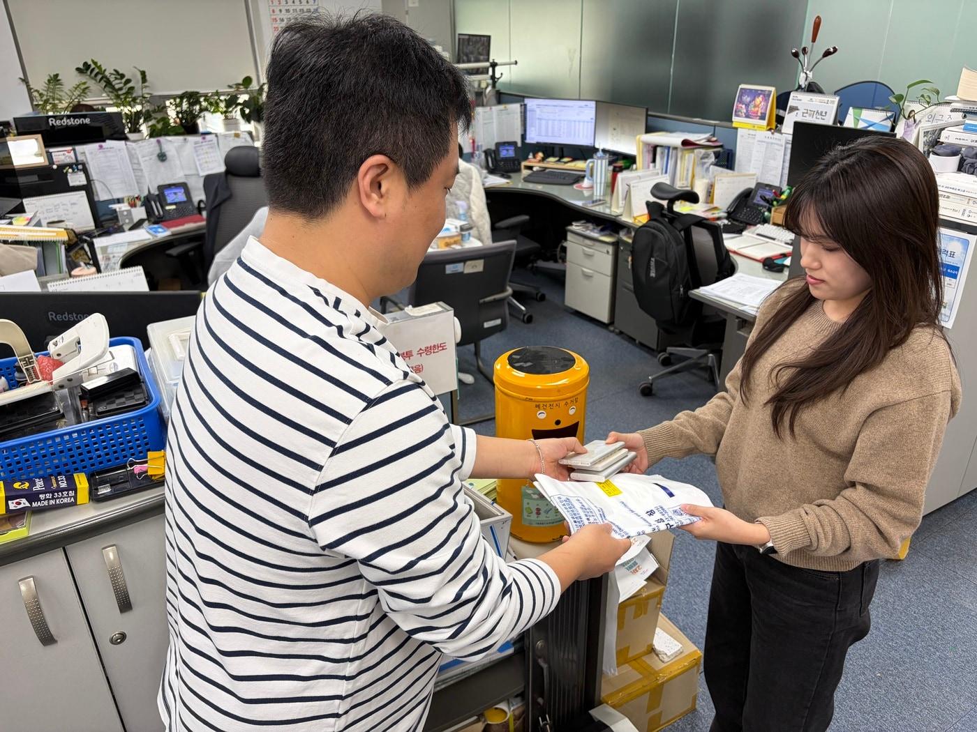 본문 이미지 - 도봉구민이 폐보조배터리 등을 종량제봉투로 교환 받고 있다.(도봉구 제공)