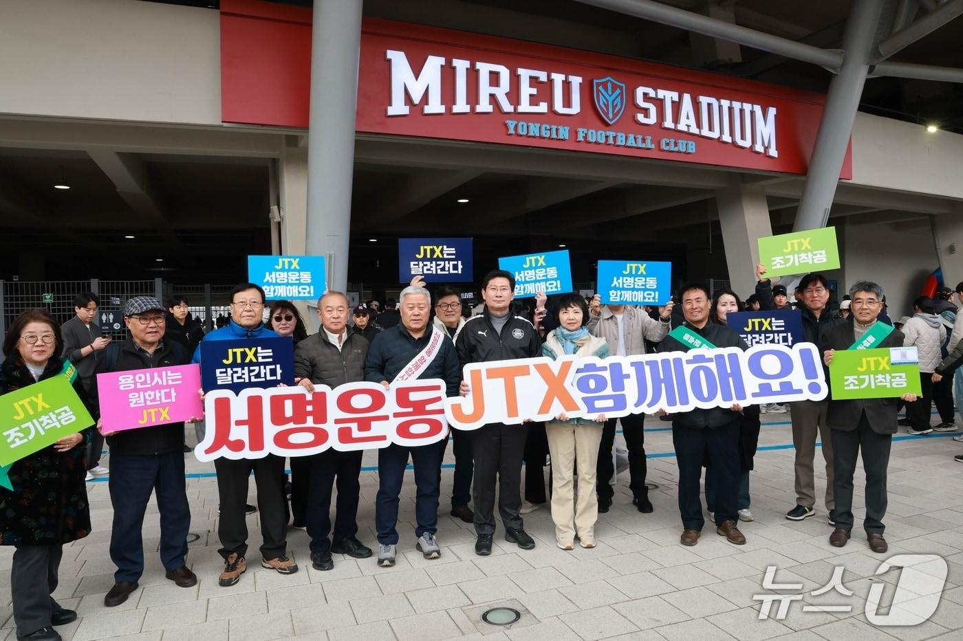 본문 이미지 - 이상일 시장(검은색 상의 운동복)이 1일 미르스타디움에서 JTX 조기 착공을 촉구하는 서명운동에 참여한 뒤 기념사진 촬영을 하고 있다.(용인시 제공)