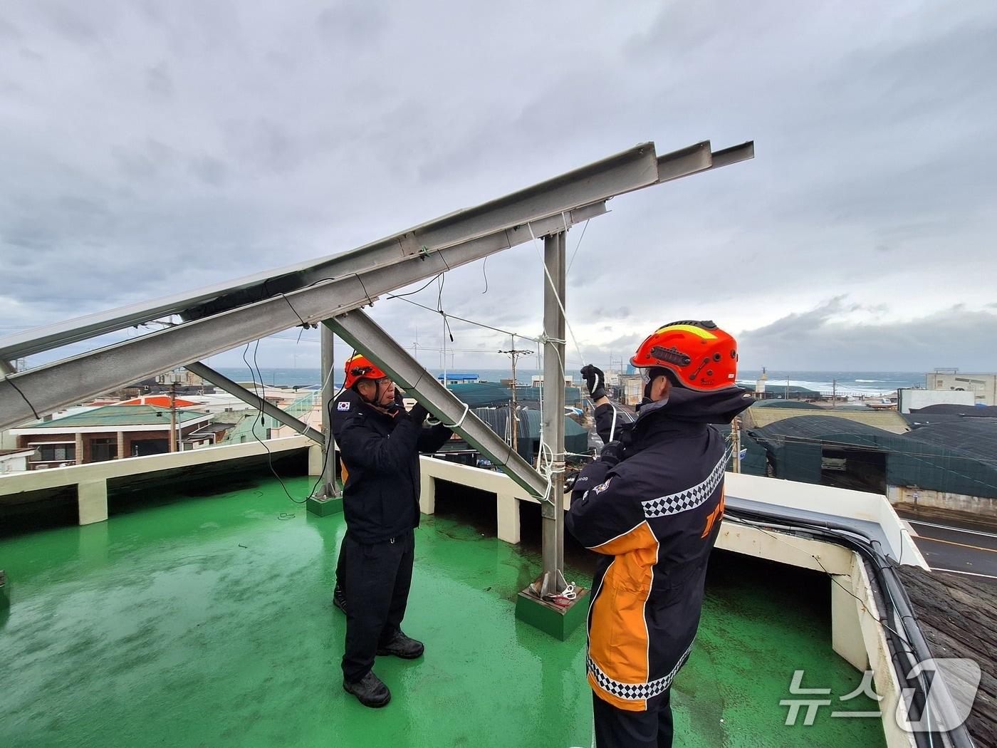 본문 이미지 -  2일 오후 제주시 한림읍의 한 주택 옥상에 설치한 태양광 패널이 강풍으로 파손돼 소방당국이 안전조치를 하고 있다./뉴스1