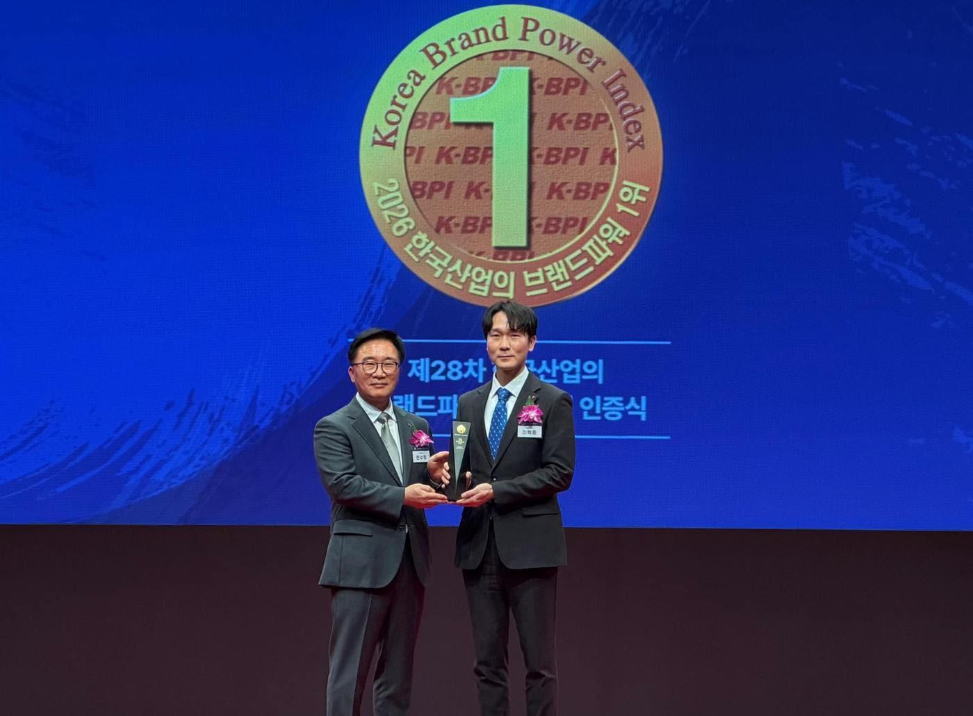 본문 이미지 - 2026년 3월 18일 한국능률협회컨설팅에서 주관하는 ‘2026 한국산업의 브랜드파워 1등 수여식에서 이혁중 롯데GRS 마케팅부문장(오른쪽)이 인증패 수여 후 기념 촬영을 하고 있다.(롯데GRS 제공)