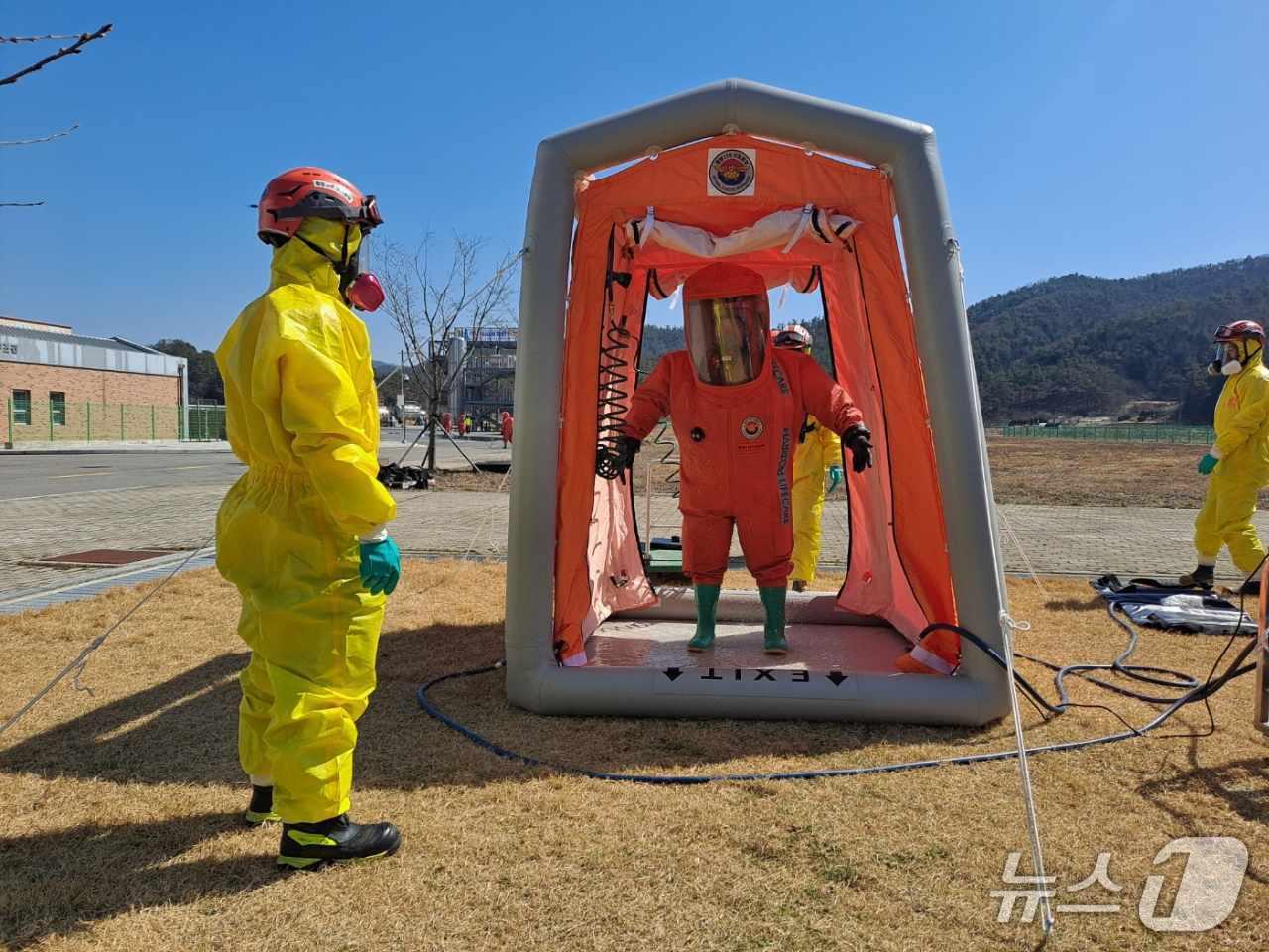 본문 이미지 - 화학사고 누출 지역에서 임무를 마치고 철수한 대원을 대상으로 중앙119구조본부 호남119특수구조대가 간이제독소에서 2차 오염 방지를 위한 제독 작업을 실시하고 있다.(소방청 제공)