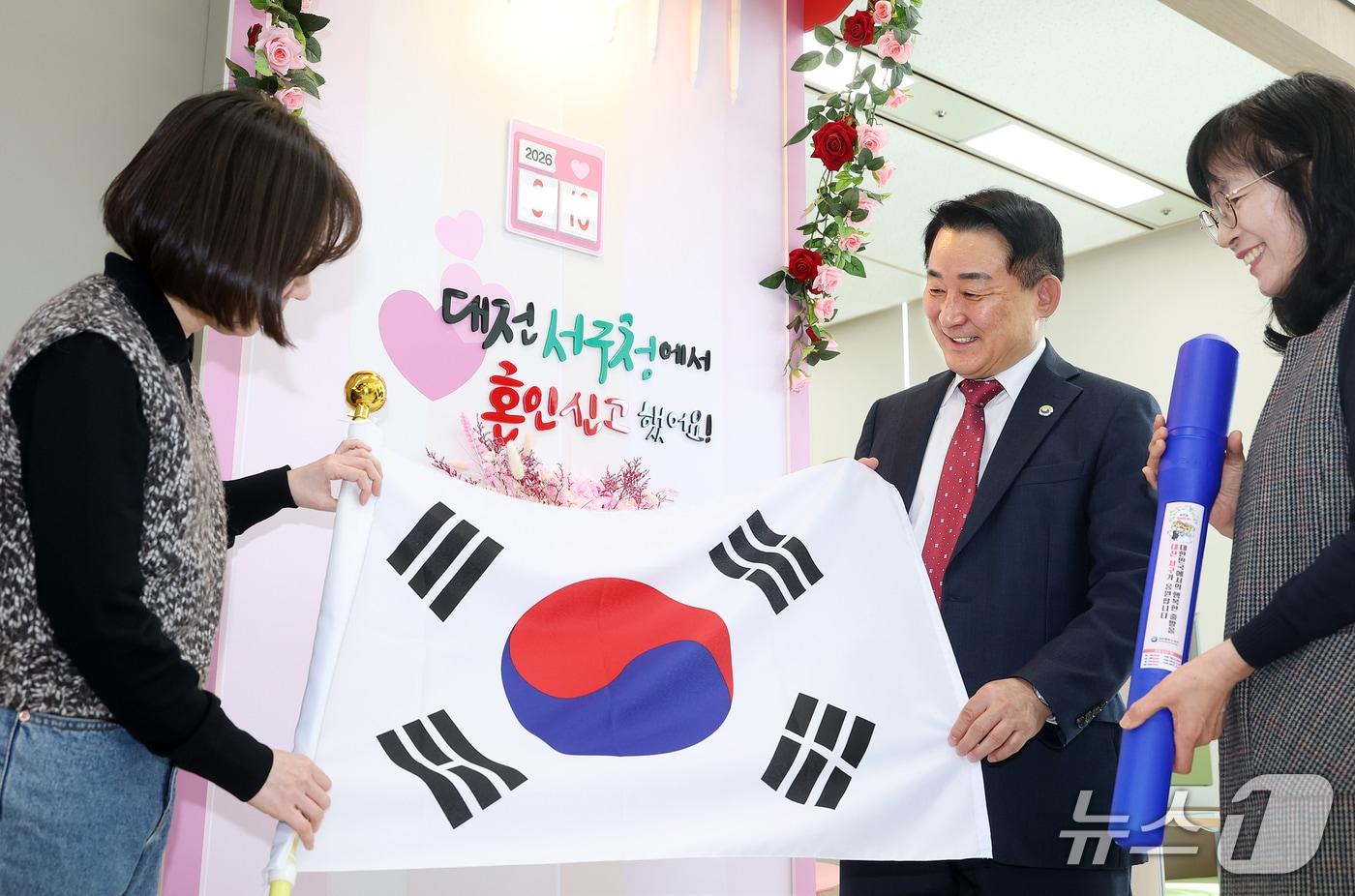 본문 이미지 - 서철모 서구청장이 구청 민원실을 방문한 국제결혼 부부에게 태극기를 전하고 있다.(서구 제공. 재판매 및 DB금지)/뉴스1