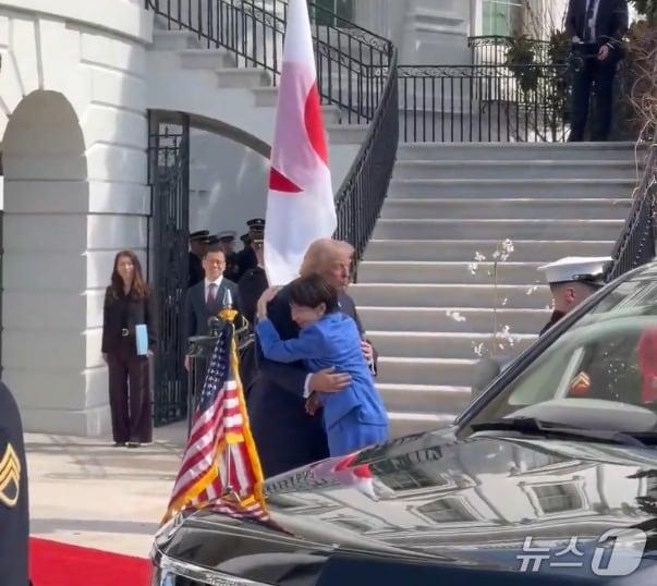 본문 이미지 - 다카이치 사나에 일본 총리가 19일 자신에게 악수하려 다가온 도널드 트럼프 미국 대통령을 껴안고 있다. 2026.3.19 (마고 마틴 백악관 공보관 엑스 캡처)