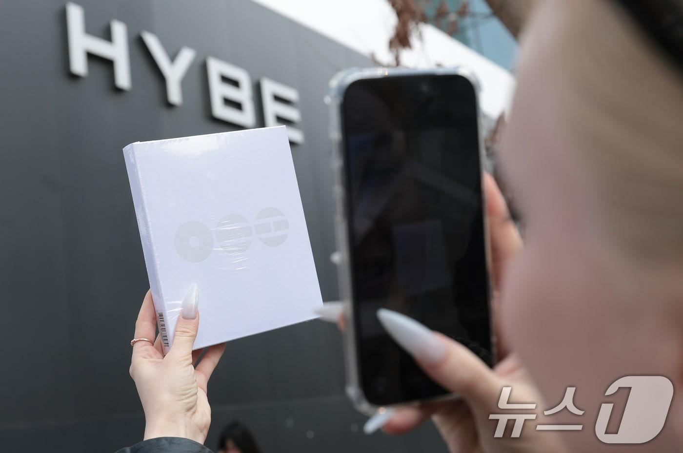 본문 이미지 - 그룹 방탄소년단(BTS)의 광화문 공연을 앞둔 20일 서울 용산구 하이브 앞에서 한 러시아 팬이 기념 촬영을 하고 있다. 2026.3.20 ⓒ 뉴스1 권현진 기자