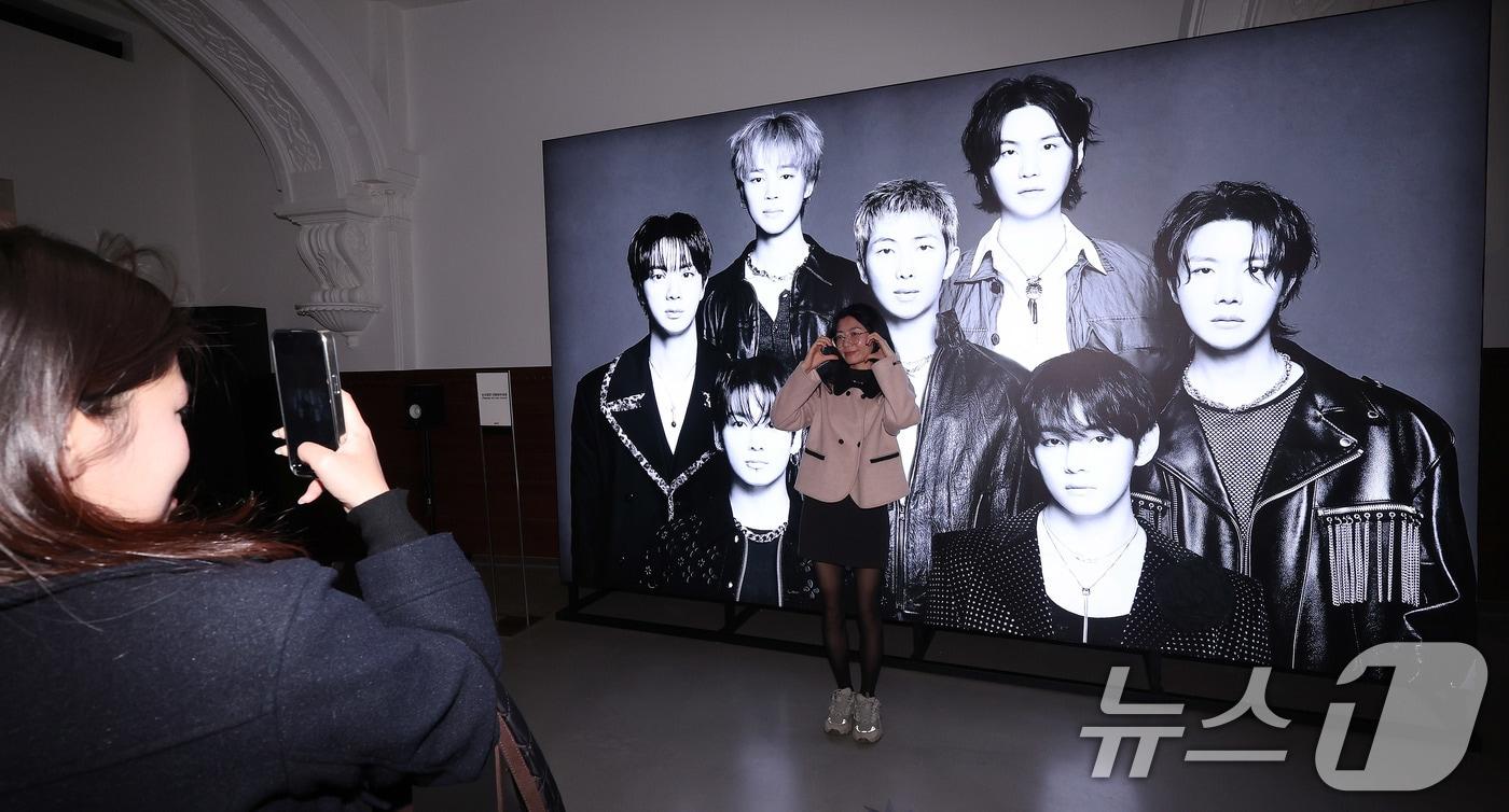 본문 이미지 - 20일 서울 중구 신세계백화점 본점 헤리티지 뮤지엄에 마련된 ‘BTS POP-UP : ARIRANG’에서 외국인 관광객들이 전시를 둘러보고 있다. 신세계백화점은 하이브(HYBE)와 함께 방탄소년단(BTS) 완전체 컴백 분위기를 미리 체험할 수 있는 팝업스토어를 본점 더 헤리티지 4층에 마련했다. 2026.3.20 ⓒ 뉴스1 박지혜 기자
