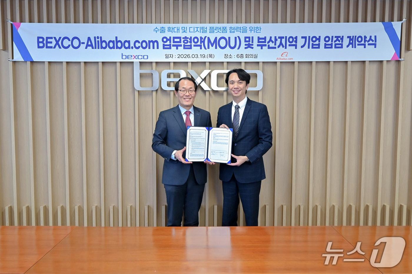 본문 이미지 - 19일 부산 해운대구 벡스코에서 열린 업무협약식에서 이준승 벡스코 대표이사(왼쪽)와 마르코 양 알리바바닷컴 한국지사장이 협약서를 들어 보이고 있다. (벡스코 제공. 재판매 및 DB 금지)