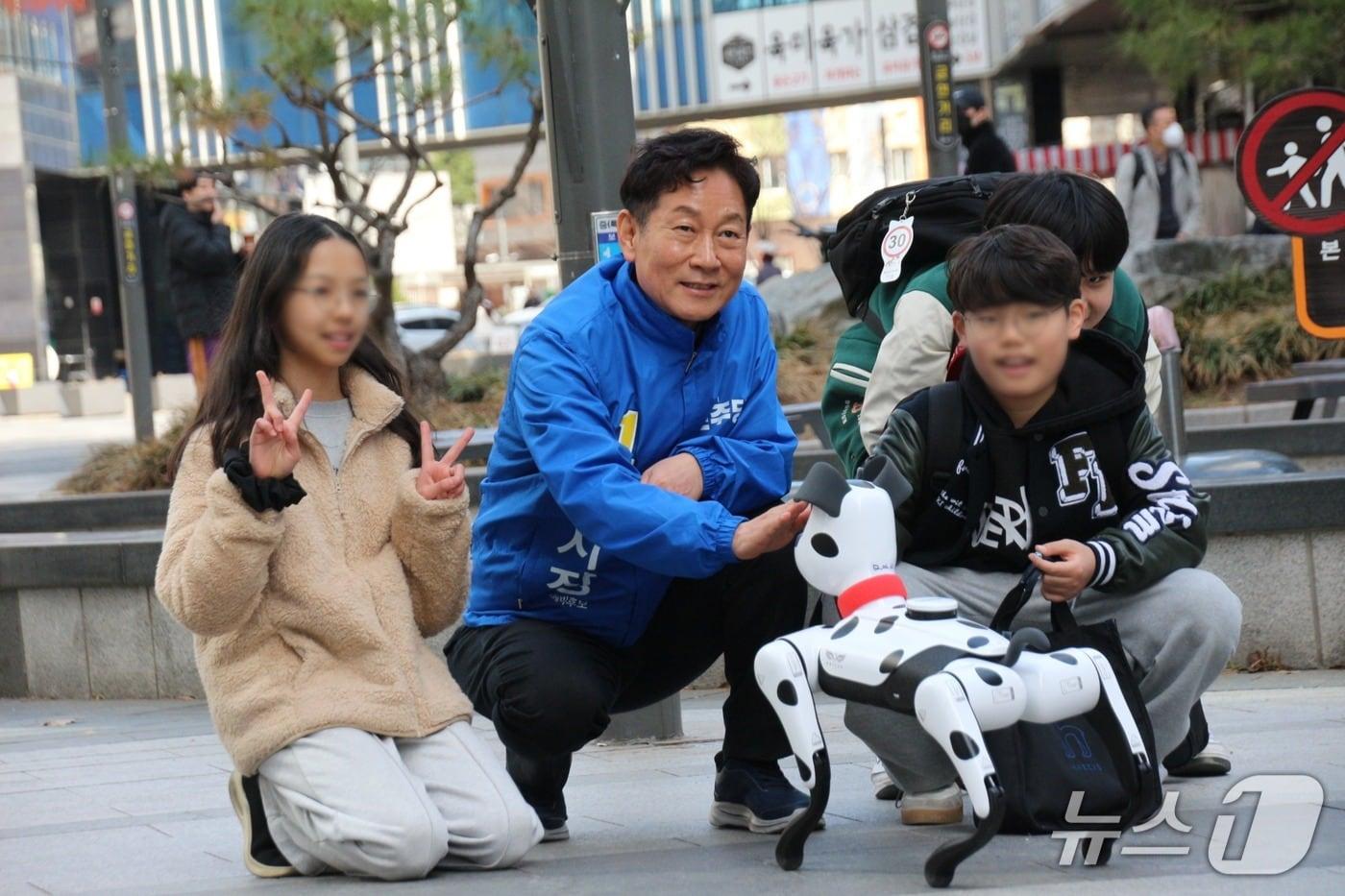 본문 이미지 -  강병덕 더불어민주당 경기 하남시장 예비후보(61)가 지난 19일 하남시 미사문화거리 일대에서 로봇개를 동원한 이색 선거운동을 하고 있다.(강 예비후보 측 제공. 재판매 및 DB 금지)/뉴스1