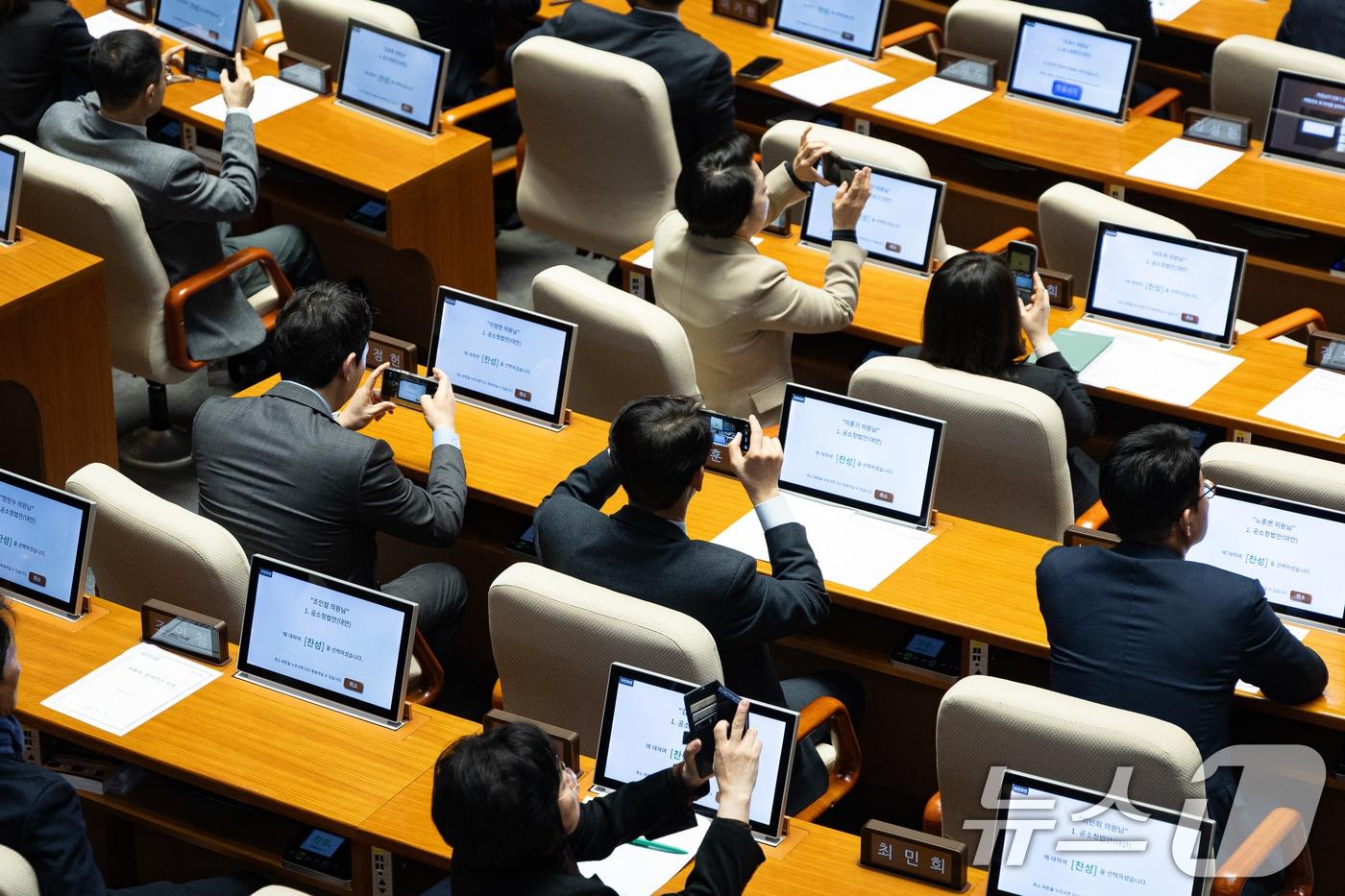 본문 이미지 - 더불어민주당 의원들이 지난 20일 서울 여의도 국회에서 열린 제433회 국회(임시회) 제2차 본회의에서 공소청법안(대안) 표결 후 휴대전화로 결과를 촬영하고 있다. 2026.3.20 ⓒ 뉴스1 유승관 기자