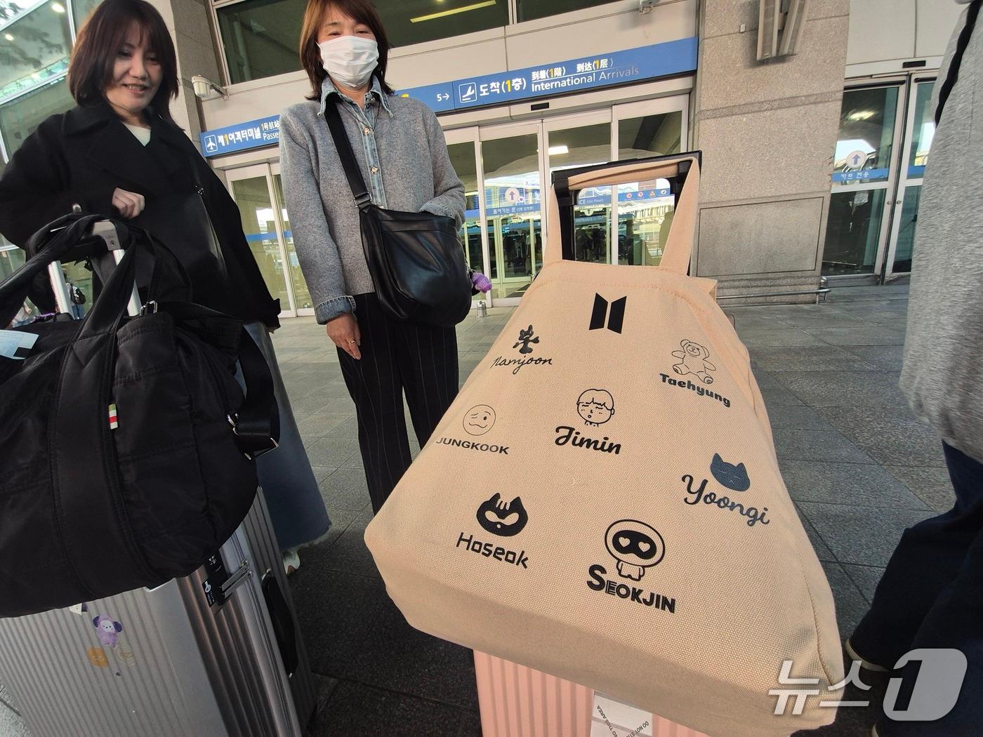 본문 이미지 - 20일 인천 중구 인천국제공항 제1여객터미널 공항버스 정류장에서 만난 아이코, 사이코 씨의 옆 캐리어에는 BTS 캐릭터가 담겨진 손가방이 걸려있었다./뉴스1