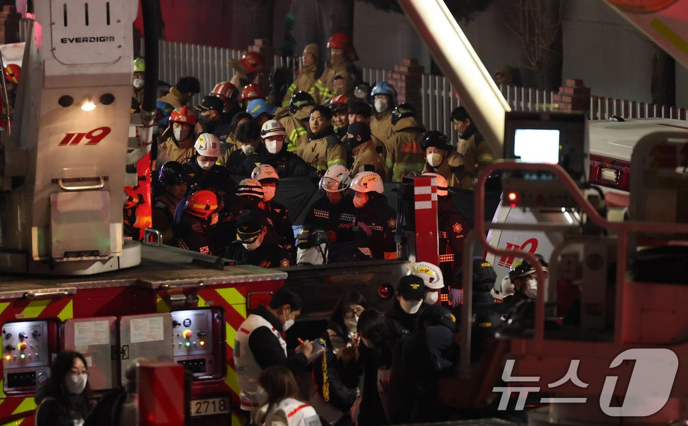 본문 이미지 - 20일 오후 1시17분께 대전 대덕구 문평동 자동차 부품공장에서 발생한 대형 화재로 14명 실종, 소방대원들이 인명 수색을 벌여 발견된 시신을 이송하고 있다. ⓒ 뉴스1 김기태 기자