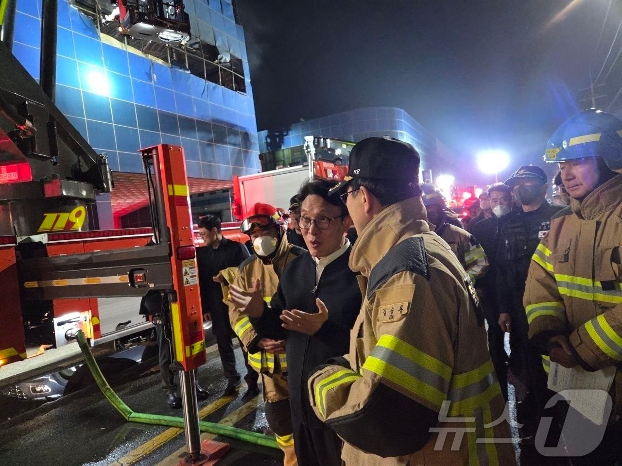 본문 이미지 - 김민석 국무총리가 20일 화재가 발생한 대전 대덕구 문평동 자동차 부품 제조 공장을 찾아 소방 관계자로부터 화재 현황에 대해 보고 받고 있다. (총리실 제공. 재판매 및 DB 금지) 2026.3.21 ⓒ 뉴스1