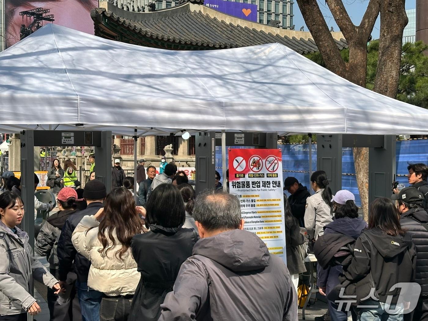 본문 이미지 - 아이돌그룹 방탄소년단(BTS)의 컴백 공연이 열리는 서울 광화문 광장 인근에 설치된 안전게이트에서 경찰들이 시민들에 대한 검문검색을 실시하고 있다. 2026.03.21/ⓒ 뉴스1 강서연 기자