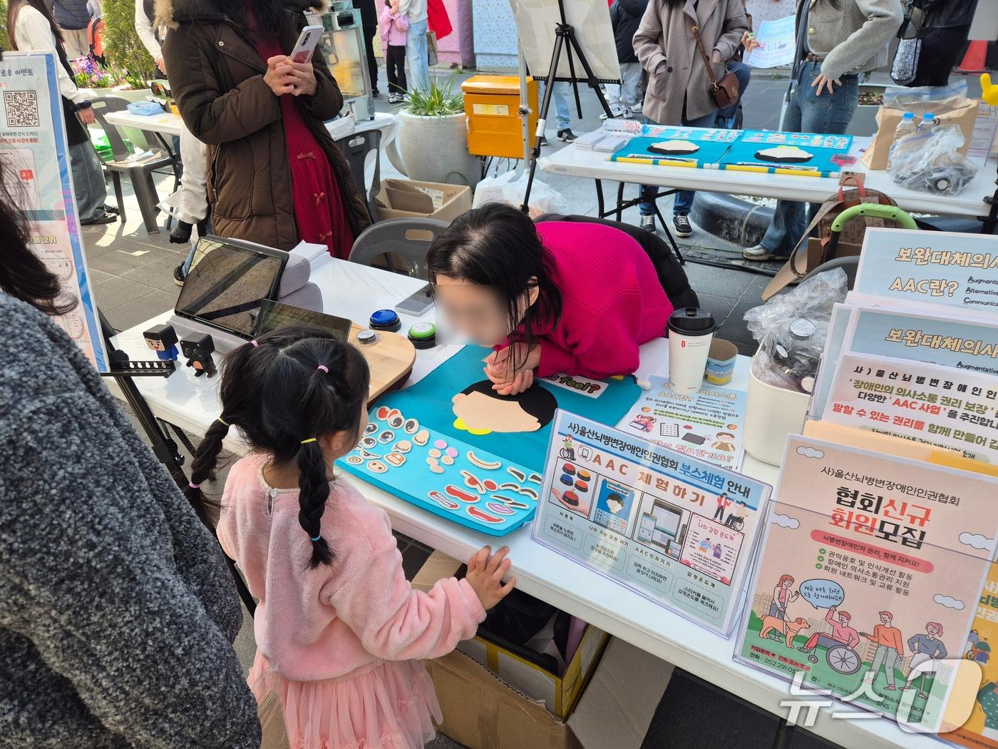 본문 이미지 - 21일 울산 중구 성남동 문화의거리에서 열린 '제8회 중구복지박람회'의 울산뇌병변장애인인권협회 부스에서 한 어린이가 체험하고 있다.2026.3.21ⓒ 뉴스1 박정현 기자