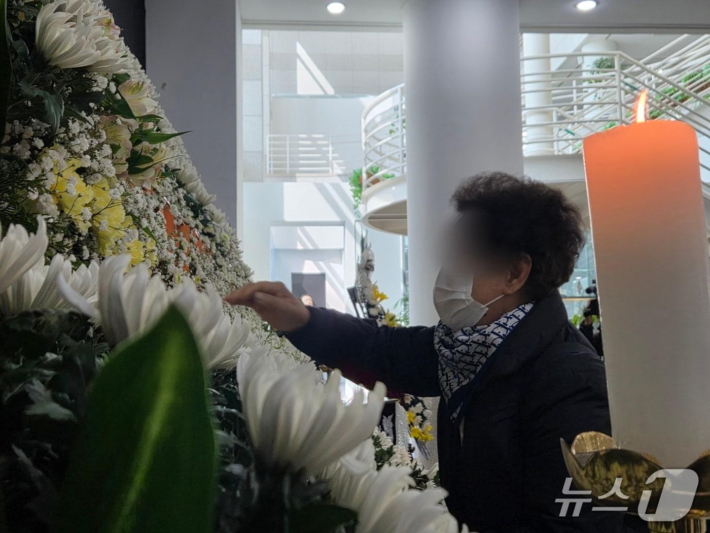 본문 이미지 - 한 유가족이 자신의 아들 위패를 어루만지며 울고 있다.2026.3.22/뉴스1