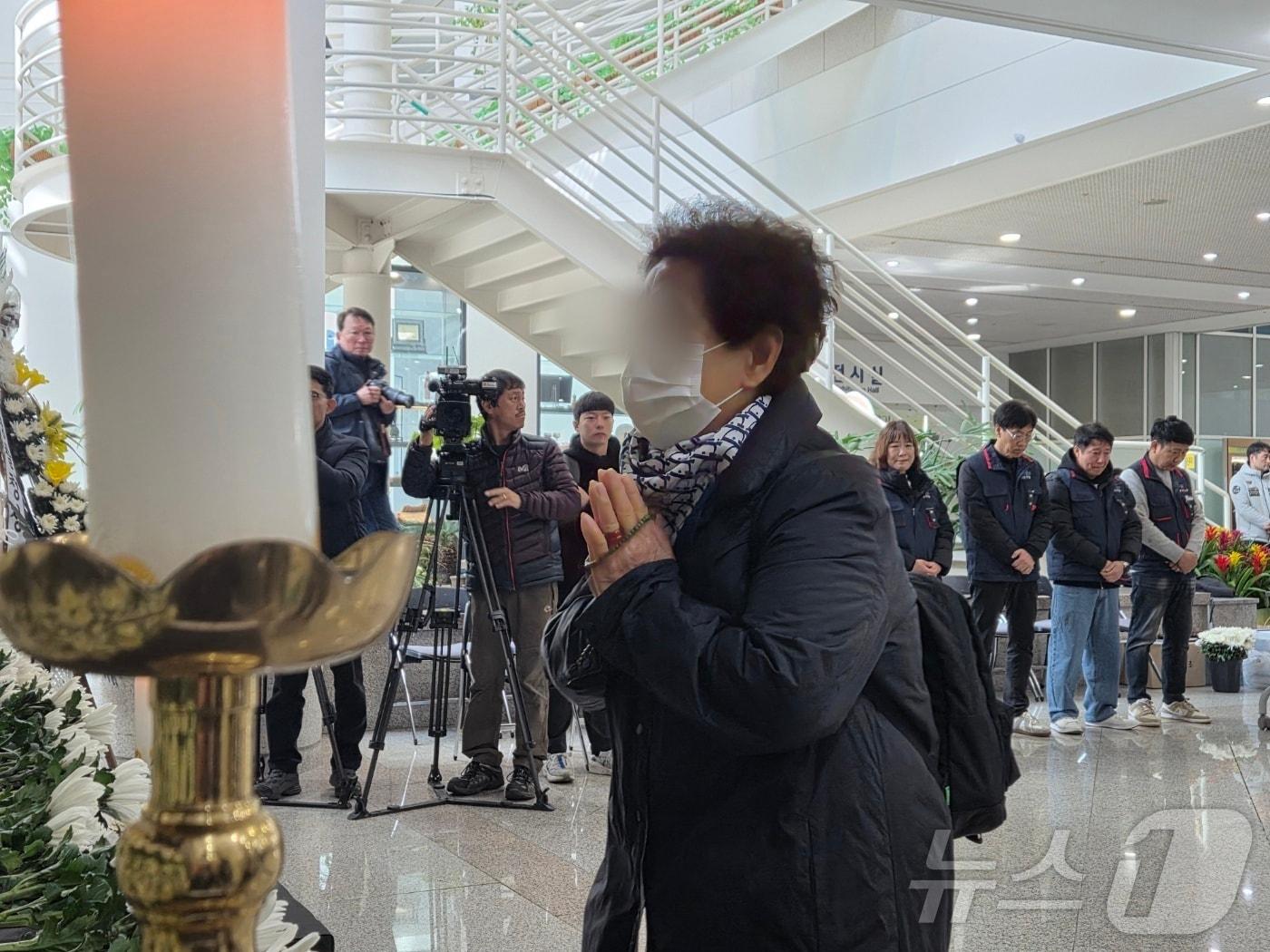 본문 이미지 - 22일 오전 대전시청 1층에 마련된 대전 공장 화재 사망자 합동분향소에서 유족이 손을 모아 기도하고 있다. 2026.3.22 ⓒ 뉴스1 김종서 기자