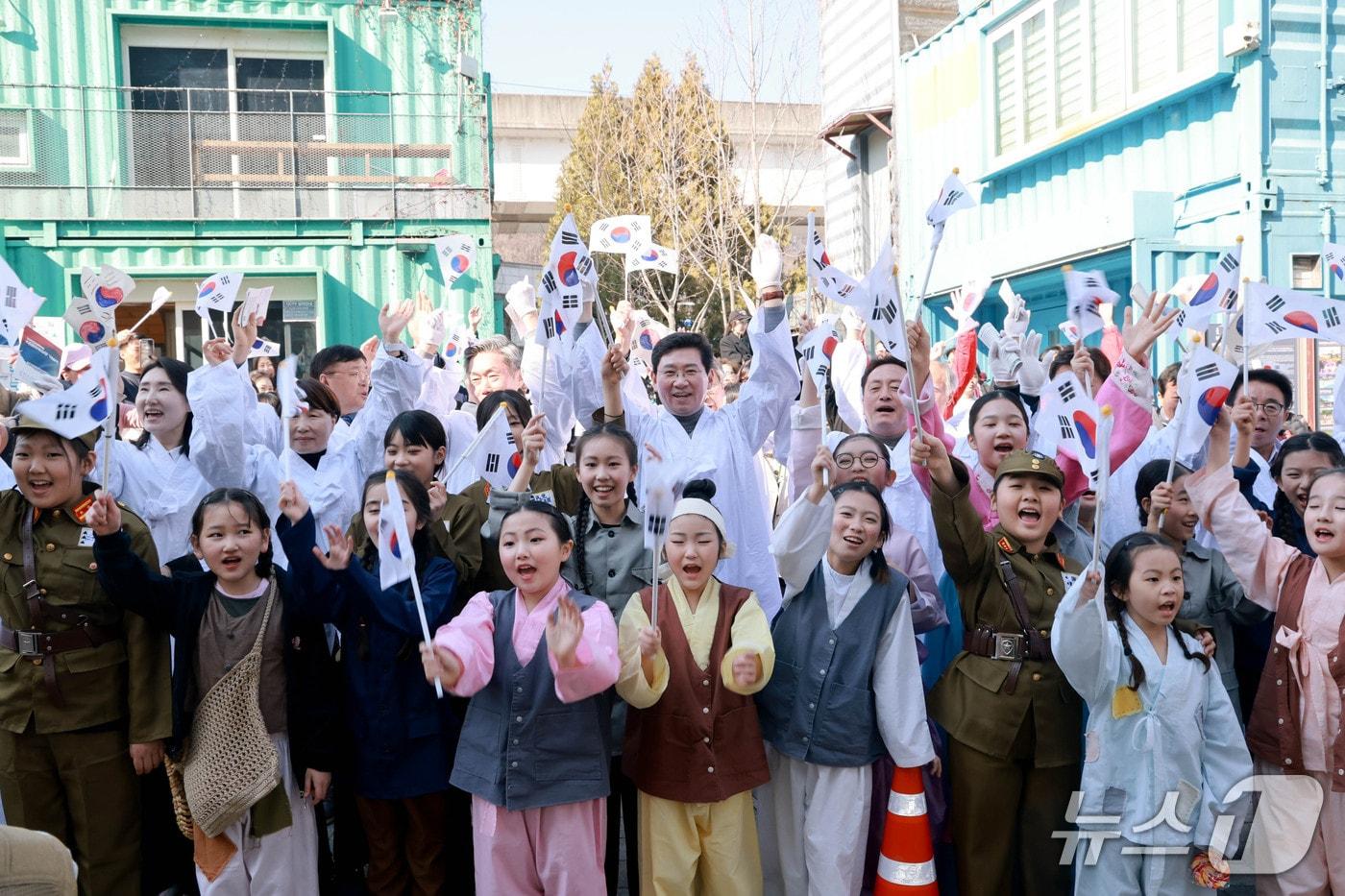 본문 이미지 - 지난 21일 용인중앙시장에서 열린 '107주년 김량장 독립만세운동 기념행사'에서 참석자들이 당시 만세운동을 재현하고 있는 모습.(용인시 제공)