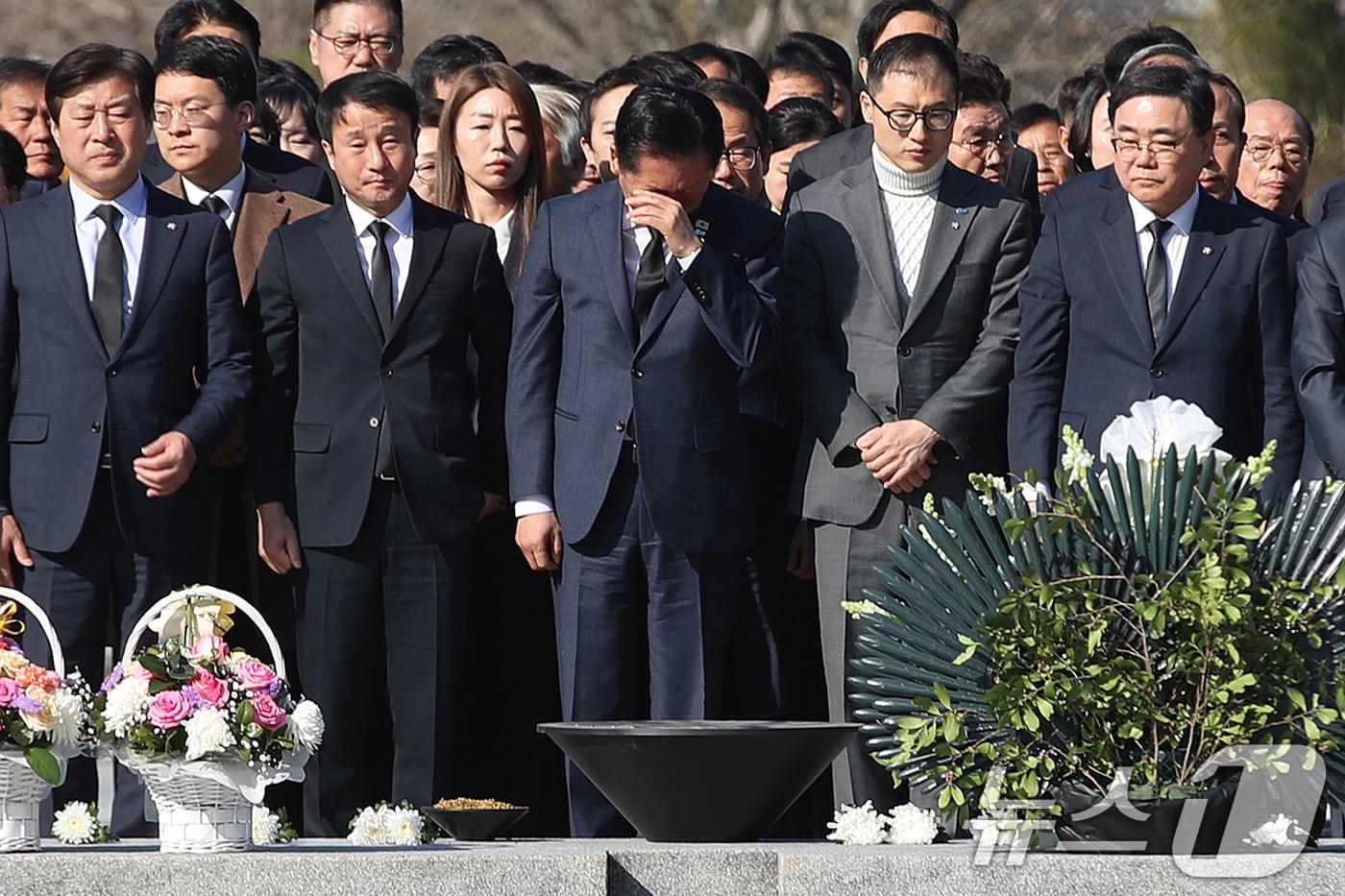 본문 이미지 - 정청래 더불어민주당 대표가 23일 오전 경남 김해 진영읍 봉하마을을 찾아 고 노무현 전 대통령 묘역을 참배하며 손으로 얼굴을 닦고 있다. 2026.3.23 ⓒ 뉴스1 윤일지 기자