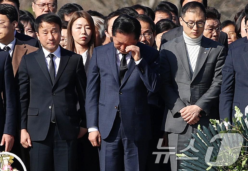 본문 이미지 - 정청래 더불어민주당 대표가 23일 오전 경남 김해 진영읍 봉하마을을 찾아 고 노무현 전 대통령 묘역을 참배하며 손으로 얼굴을 닦고 있다. 2026.3.23 ⓒ 뉴스1 윤일지 기자