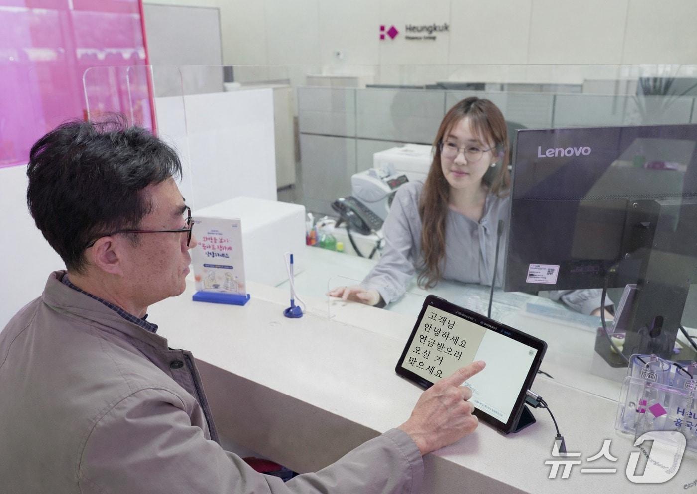 본문 이미지 - 서울 종로구 흥국생명 본사 금융플라자에서 고령 고객과 직원이 ‘AI 실시간 자막 서비스’를 이용해 금융 상담을 진행하고 있다/사진제공=흥국생명