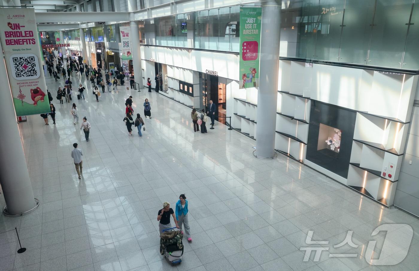 본문 이미지 - 달러·원 환율이 17년 만에 1510원대를 돌파하는 등 고환율 장기화가 지속되고 있는 23일 여행객들이 인천국제공항 1터미널 면세구역을 지나가고 있다. 2026.3.23 ⓒ 뉴스1 안은나 기자