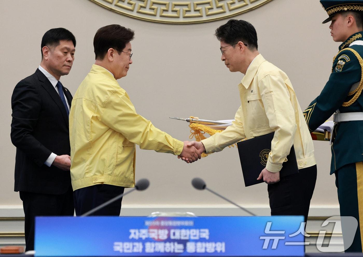 본문 이미지 - 이재명 대통령이 23일 청와대에서 열린 제59차 중앙통합방위회의에서 전남도에 대통령 단체표창을 수여한 뒤 황기연 도지사 권한대행과 악수하고 있다. 2026.3.23 ⓒ 뉴스1 이재명 기자