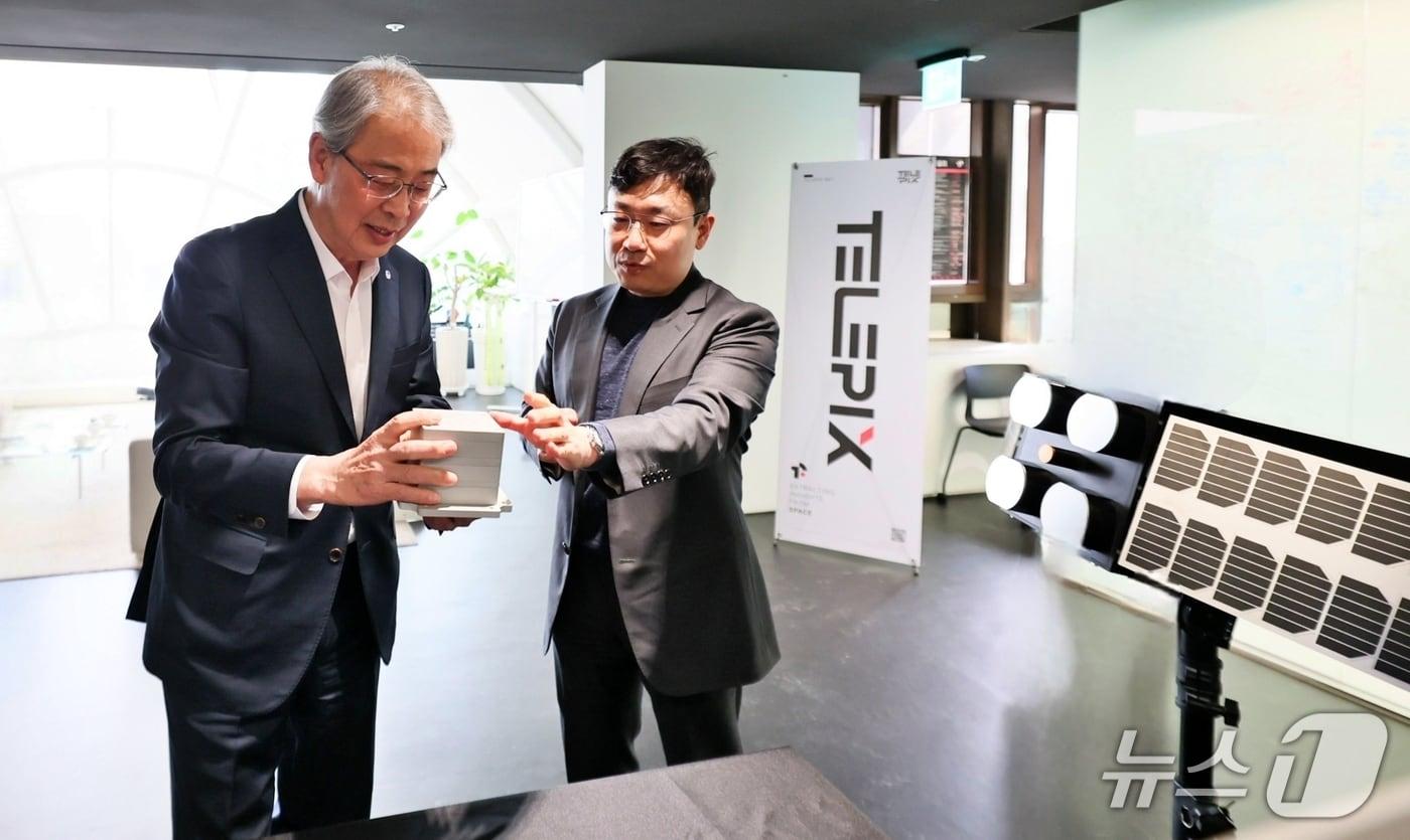 본문 이미지 - 임종룡 우리금융그룹 회장(왼쪽)이 23일 서울 여의도 텔레픽스 본사에서 조성익 대표(오른쪽)에게 제품 설명을 듣고 있다. 2026.03.23 / 사진제공=우리금융그룹