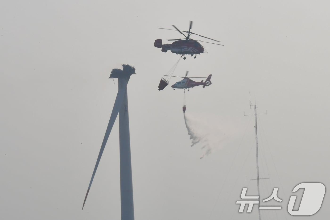본문 이미지 - 23일 오후 경북 영덕군 창포리 풍력발전단지 내 풍력발전기에서 발생한 화재 진화를 위해 산림청, 소방, 인근 지자체 진화핼기들이 진화 작업을 벌이고 있다. 2026.3.23 ⓒ 뉴스1 최창호 기자