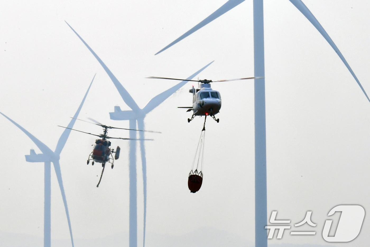 본문 이미지 - 23일 오후 경북 영덕군 창포리 풍력발전단지 내 풍력발전기에서 발생한 불을 끄기 위해 산림청, 소방, 인근 지자체 진화핼기들이 진화작업을 벌이고 있다. 2026.3.23 ⓒ 뉴스1 최창호 기자