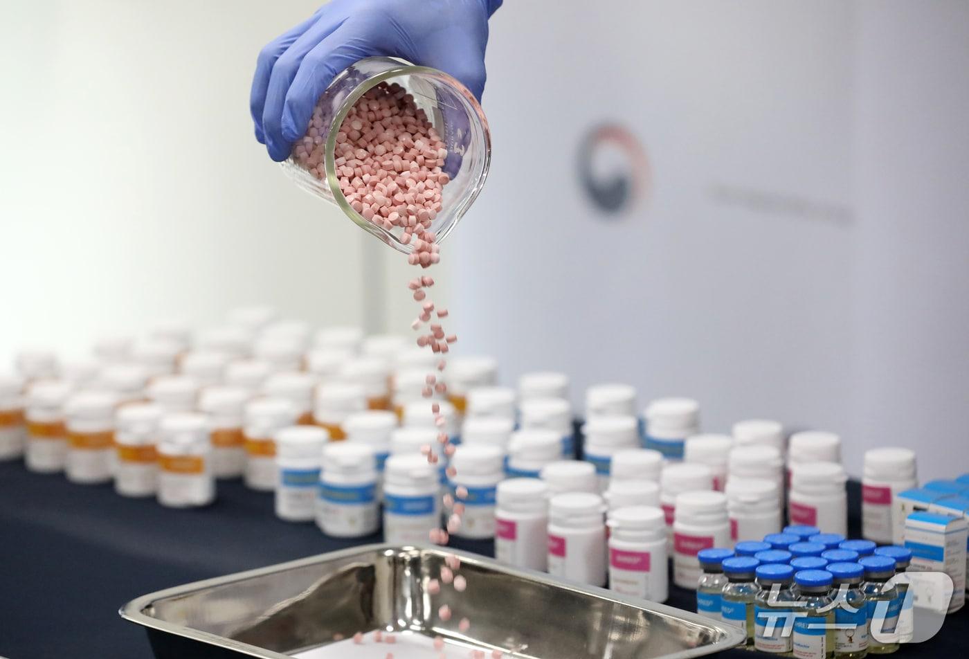 본문 이미지 - 24일 오전 부산 연제구 부산지방식약청 브리핑실에서 전신마취제 에토미데이트와 아나볼릭 스테로이드 등 44억 원 상당 전문의약품 불법 유통 적발 브리핑이 진행된 가운데 관계자가 스테로이드를 쏟아붓고 있다.2026.3.24/뉴스1 ⓒ News1 윤일지 기자