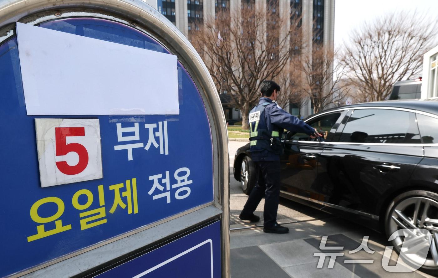 본문 이미지 - 24일 서울 종로구 정부서울청사 앞에 원유 안보위기 ‘주의’ 경보 발령에 따른 공공 차량 5부제 안내문이 붙어있다. 공공부문은 선도적으로 에너지절약을 실천하기 위해 25일부터 전기차와 수소차를 제외한 승용차 5부제를 의무적으로 시행한다. 2026.3.24 ⓒ 뉴스1 임세영 기자