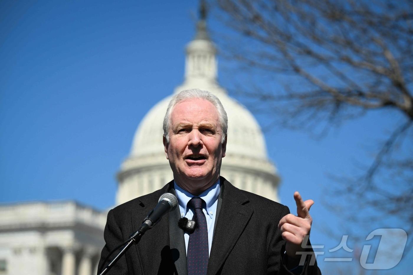 본문 이미지 - 미국 민주당 소속 크리스 밴 홀런 상원의원(메릴랜드주)이 18일(현지시간) 미국 국회의사당 앞에서 이란 전쟁을 끝내야 한다고 발언했다. 현장에는 이란 미나브 초등학교 폭격으로 희생된 어린이들과 다른 민간인들을 상징하는 신발과 가방으로 꾸며진 추모 공간이 마련됐다.2026.03.18.ⓒ AFP=뉴스1