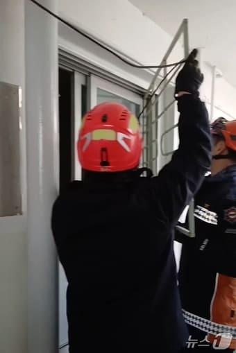 본문 이미지 - 펌프구조대가 환자가 쓰러져 있던 군산의 한 아파트 세대의 창틀을 뜯어내고 있다.(전북소방본부 제공. 재판매 및 DB금지)